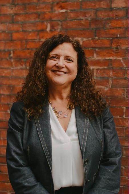Headshot in front of a brick wall in Providence, Rhode Island