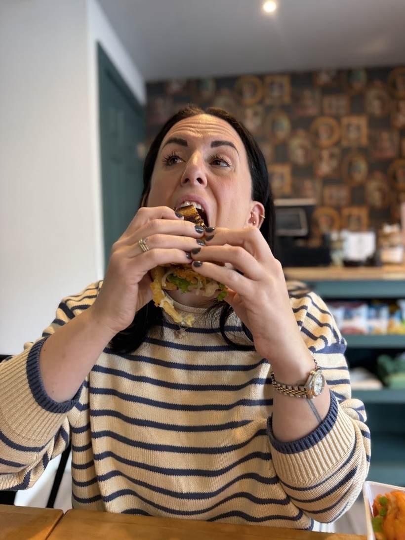 Emily Homonoff taking a big bite of a sandwich