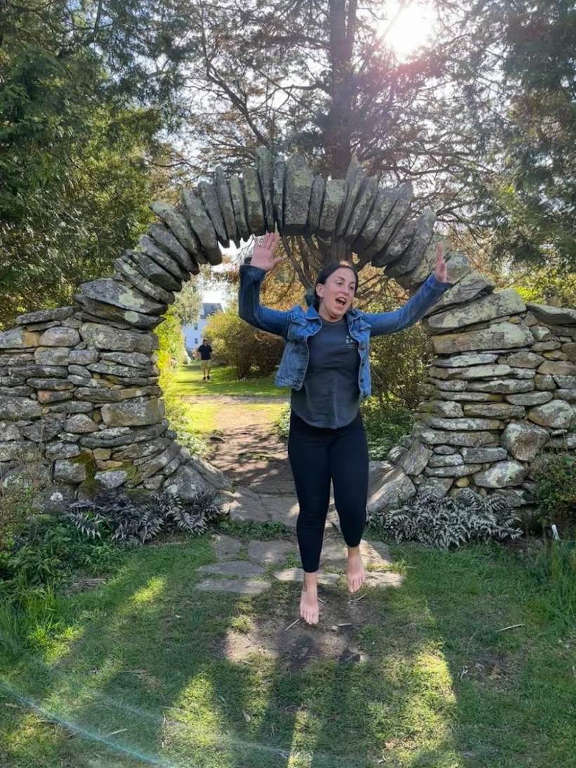 Emily jumping through a stone archway