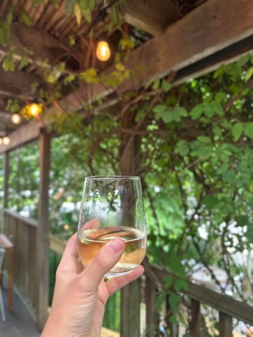 A glass of wine under twinkle lights