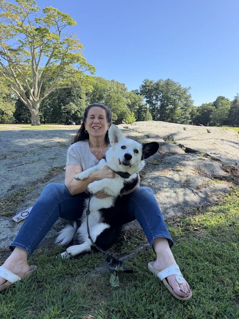 Robin Kall smiling outdoors with her dog